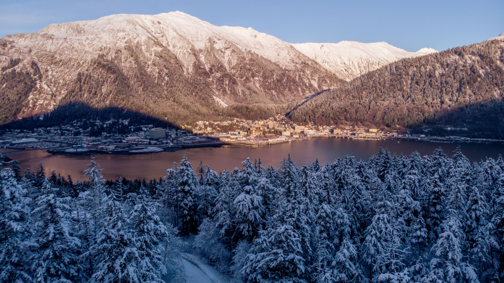 An aerial view of downtown Juneau, Alaska nestled at the base of snowy mountains